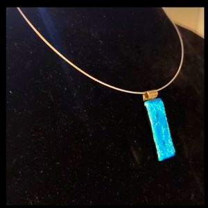 Metallic blue dichroic glass pendant, with Nia symbol